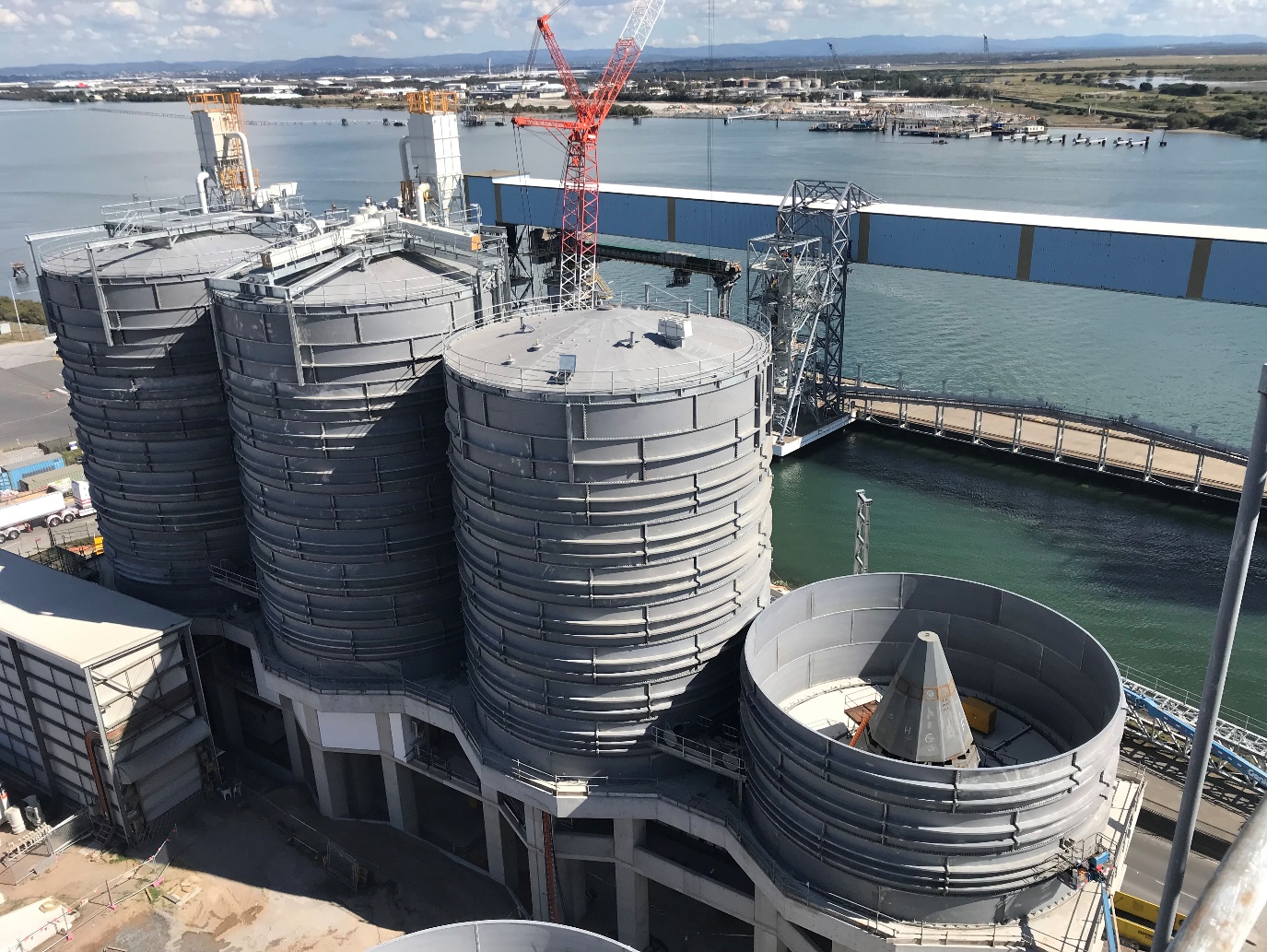 Large industrial storage silos beside a marine terminal in Australia